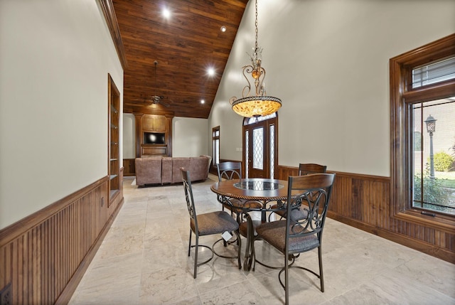 dining room featuring a wainscoted wall, wood walls, recessed lighting, wooden ceiling, and high vaulted ceiling