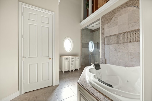 full bathroom featuring baseboards, a tub with jets, and tile patterned flooring