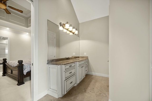 bathroom with baseboards, lofted ceiling, ceiling fan, and vanity