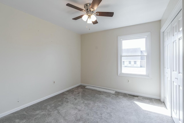 unfurnished bedroom with a ceiling fan, baseboards, visible vents, carpet floors, and a closet