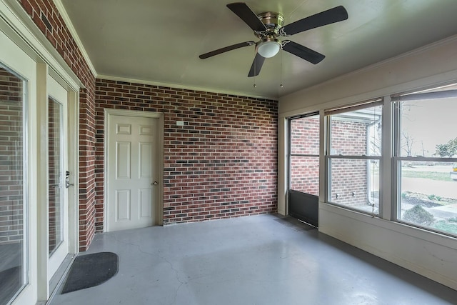 unfurnished sunroom featuring a ceiling fan