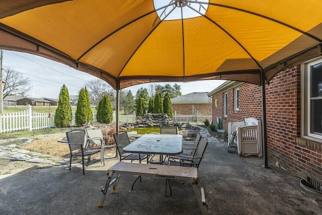 view of patio / terrace with outdoor dining space, a gazebo, and fence