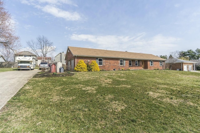 ranch-style house featuring a garage, a front yard, concrete driveway, and brick siding
