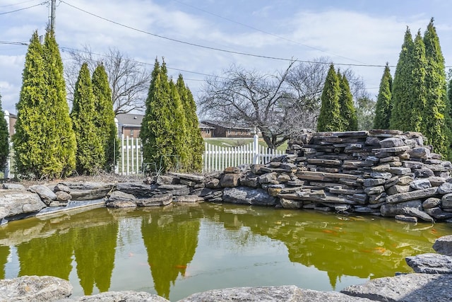 exterior space featuring a garden pond and fence