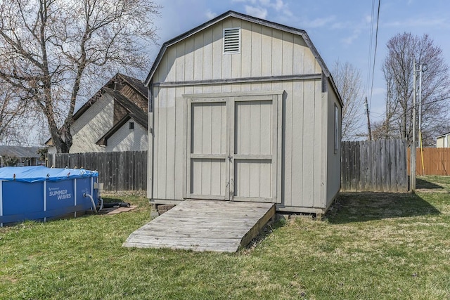 view of shed with a fenced in pool and a fenced backyard