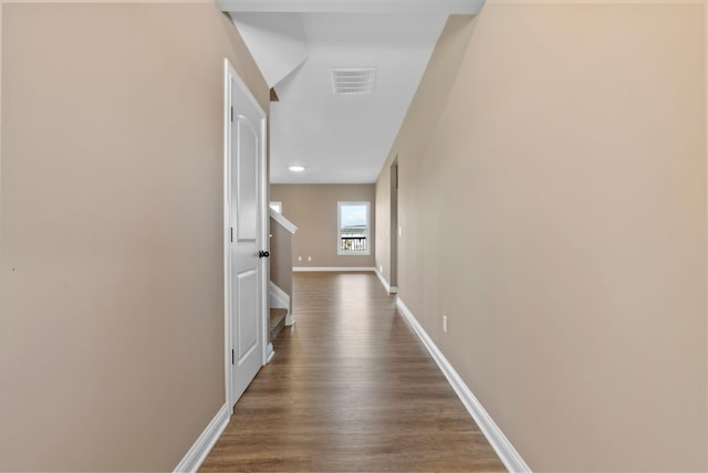 corridor with visible vents, dark wood-type flooring, and baseboards