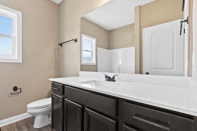 full bathroom with toilet, wood finished floors, a shower, baseboards, and vanity