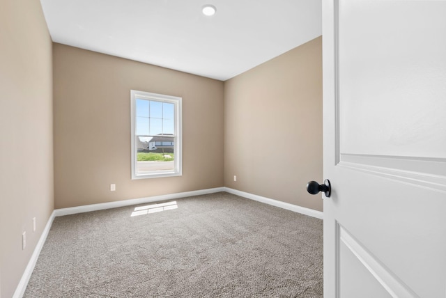 unfurnished room with carpet flooring and baseboards