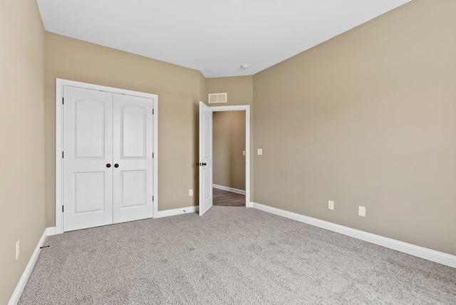 unfurnished bedroom featuring visible vents, baseboards, a closet, and carpet flooring