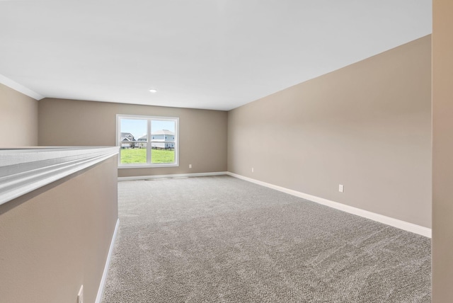 empty room featuring baseboards and carpet floors