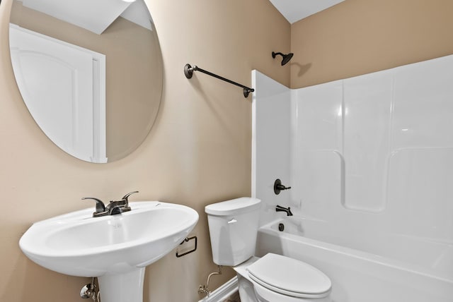 bathroom featuring toilet, shower / bathing tub combination, and a sink