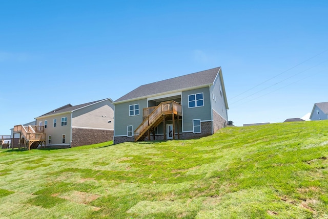 rear view of house with a deck, stairway, a yard, and brick siding