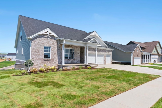 view of front facade featuring brick siding, central air condition unit, a front yard, a garage, and driveway