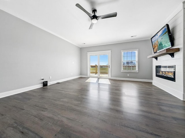 unfurnished living room with ornamental molding, dark wood-style floors, baseboards, and a large fireplace