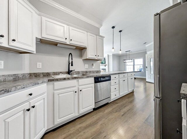 kitchen featuring a sink, stainless steel appliances, white cabinets, and crown molding