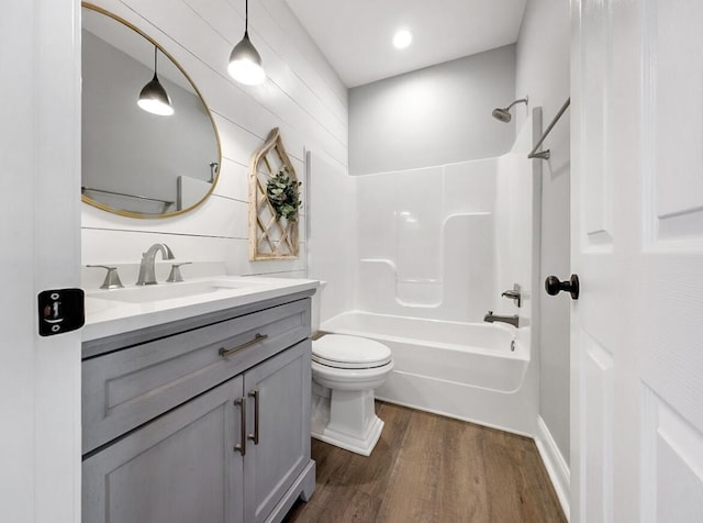 full bathroom featuring toilet,  shower combination, wood finished floors, and vanity