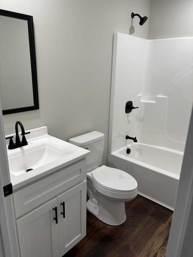 bathroom featuring toilet, vanity, shower / tub combination, and wood finished floors