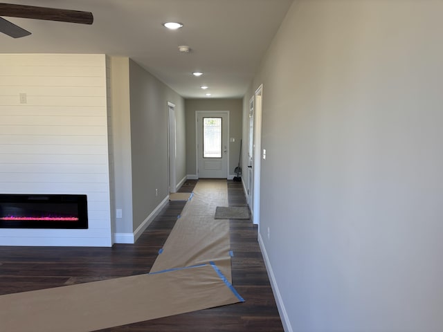 entryway featuring a glass covered fireplace, recessed lighting, baseboards, and wood finished floors