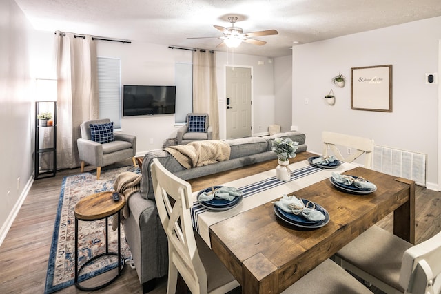 dining area with visible vents, baseboards, a textured ceiling, and wood finished floors