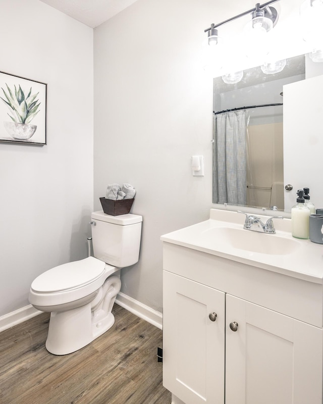 full bathroom with a shower with curtain, toilet, baseboards, and wood finished floors