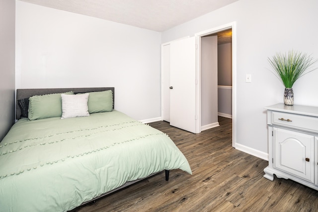 bedroom with baseboards and dark wood-style flooring