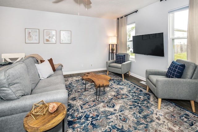 living area with wood finished floors, baseboards, and ceiling fan