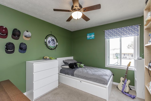 carpeted bedroom featuring a textured ceiling and ceiling fan