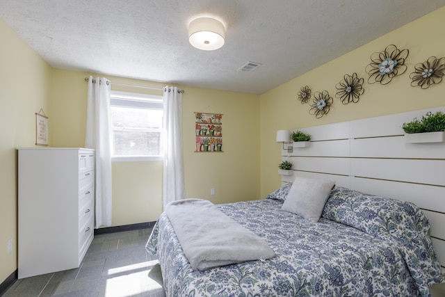 bedroom featuring visible vents and a textured ceiling