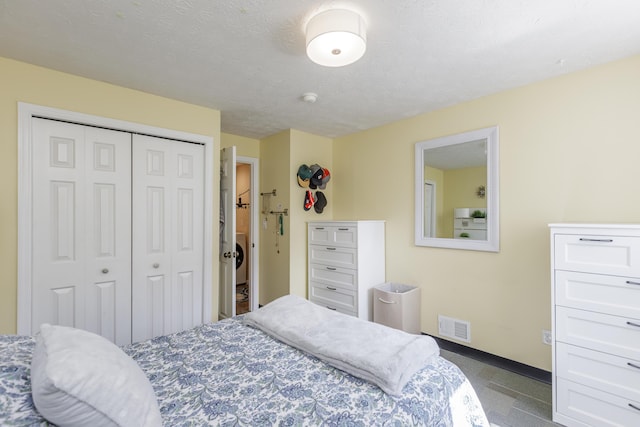 bedroom with visible vents, baseboards, a textured ceiling, and a closet