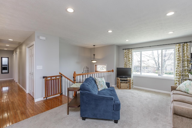 living room with recessed lighting, a textured ceiling, carpet, and baseboards