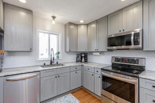 kitchen featuring a sink, appliances with stainless steel finishes, and gray cabinets