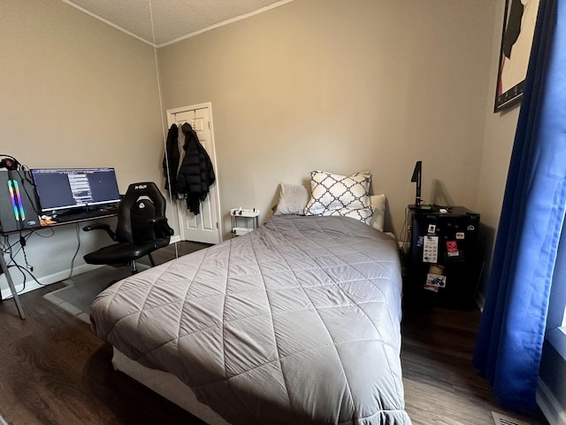 bedroom featuring wood finished floors, baseboards, and ornamental molding