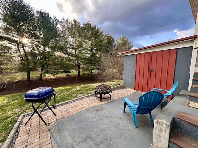 view of patio / terrace with grilling area, an outbuilding, fence, and an outdoor fire pit