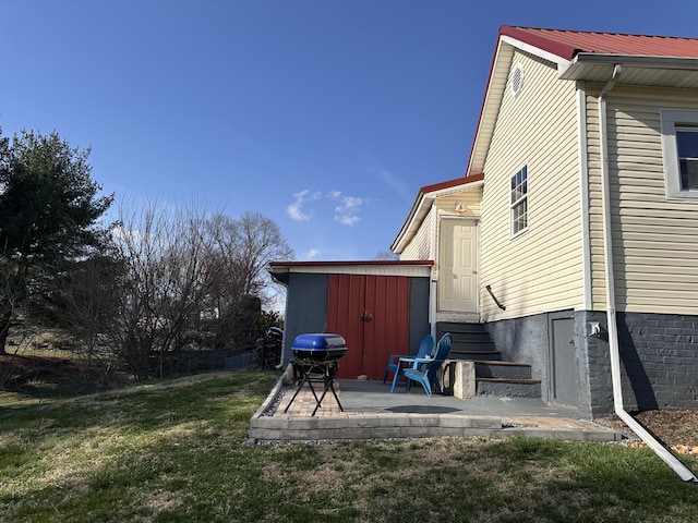 view of yard with entry steps, an outbuilding, a patio area, and a storage shed