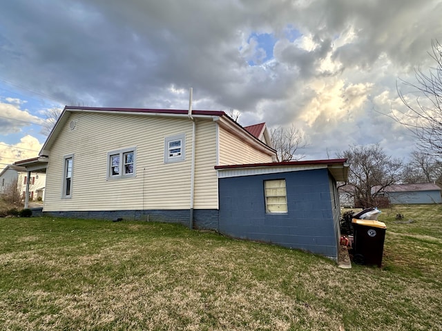 view of property exterior with metal roof and a yard