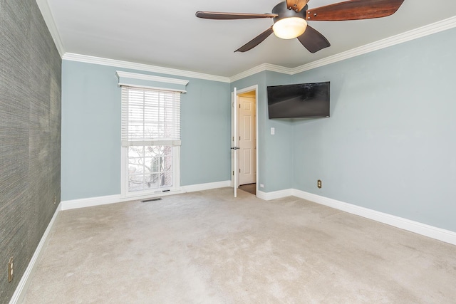 empty room featuring ceiling fan, baseboards, and ornamental molding