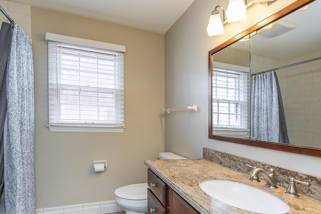 full bathroom featuring a wealth of natural light, toilet, curtained shower, and vanity