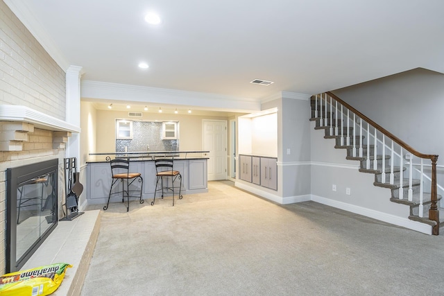 living area with stairway, visible vents, recessed lighting, ornamental molding, and light colored carpet