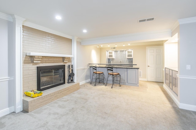 living area with light carpet, visible vents, a fireplace, and crown molding