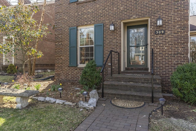 doorway to property with brick siding