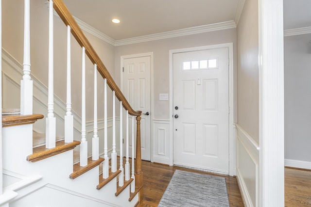 foyer entrance with wood finished floors, ornamental molding, and stairs