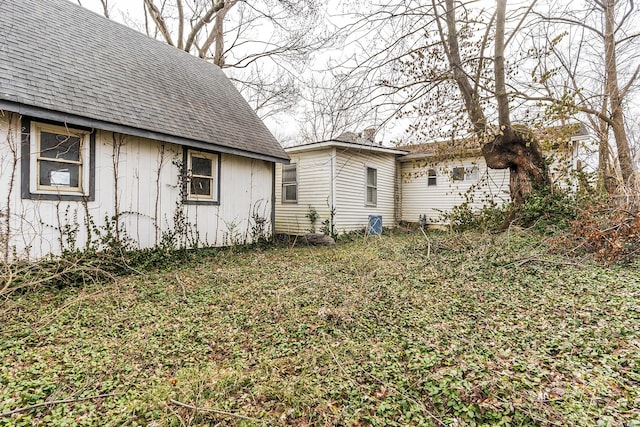 exterior space featuring roof with shingles