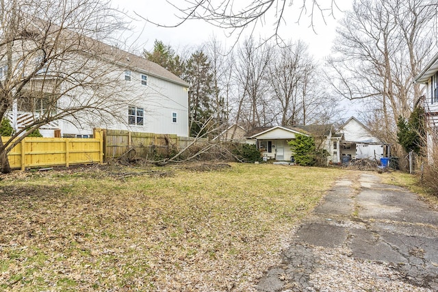 view of yard featuring aphalt driveway and fence