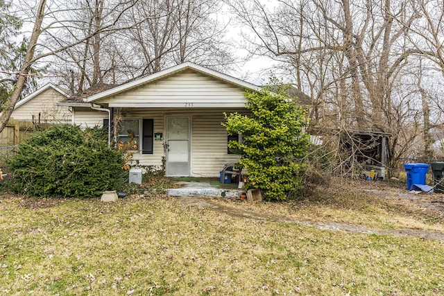 bungalow-style home featuring a front yard and covered porch