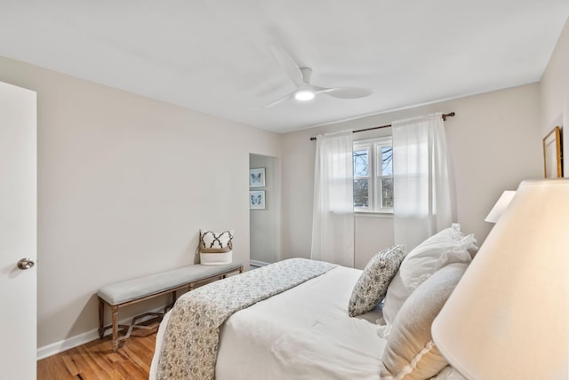 bedroom featuring baseboards, light wood-style flooring, and a ceiling fan