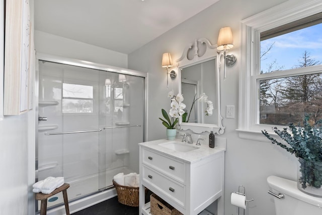 full bath featuring a stall shower, toilet, and vanity