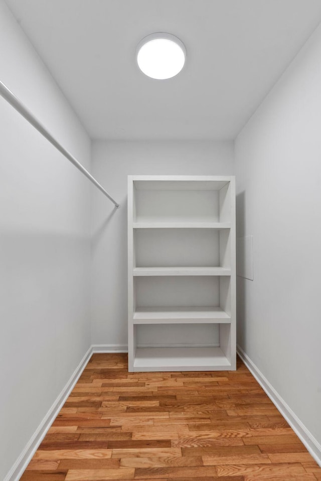 walk in closet with wood finished floors