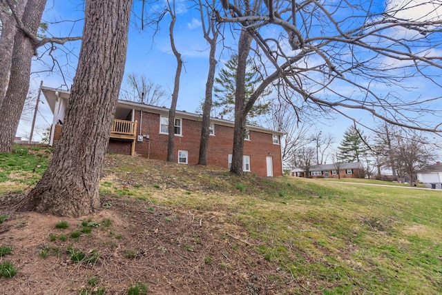 view of home's exterior with a lawn and brick siding