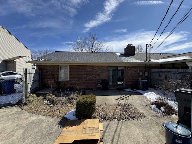 back of house with a patio, fence, brick siding, and a chimney