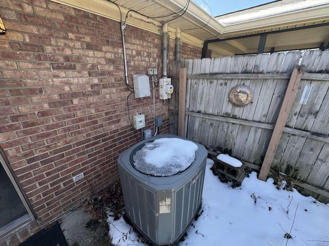 exterior details with cooling unit, brick siding, and electric meter